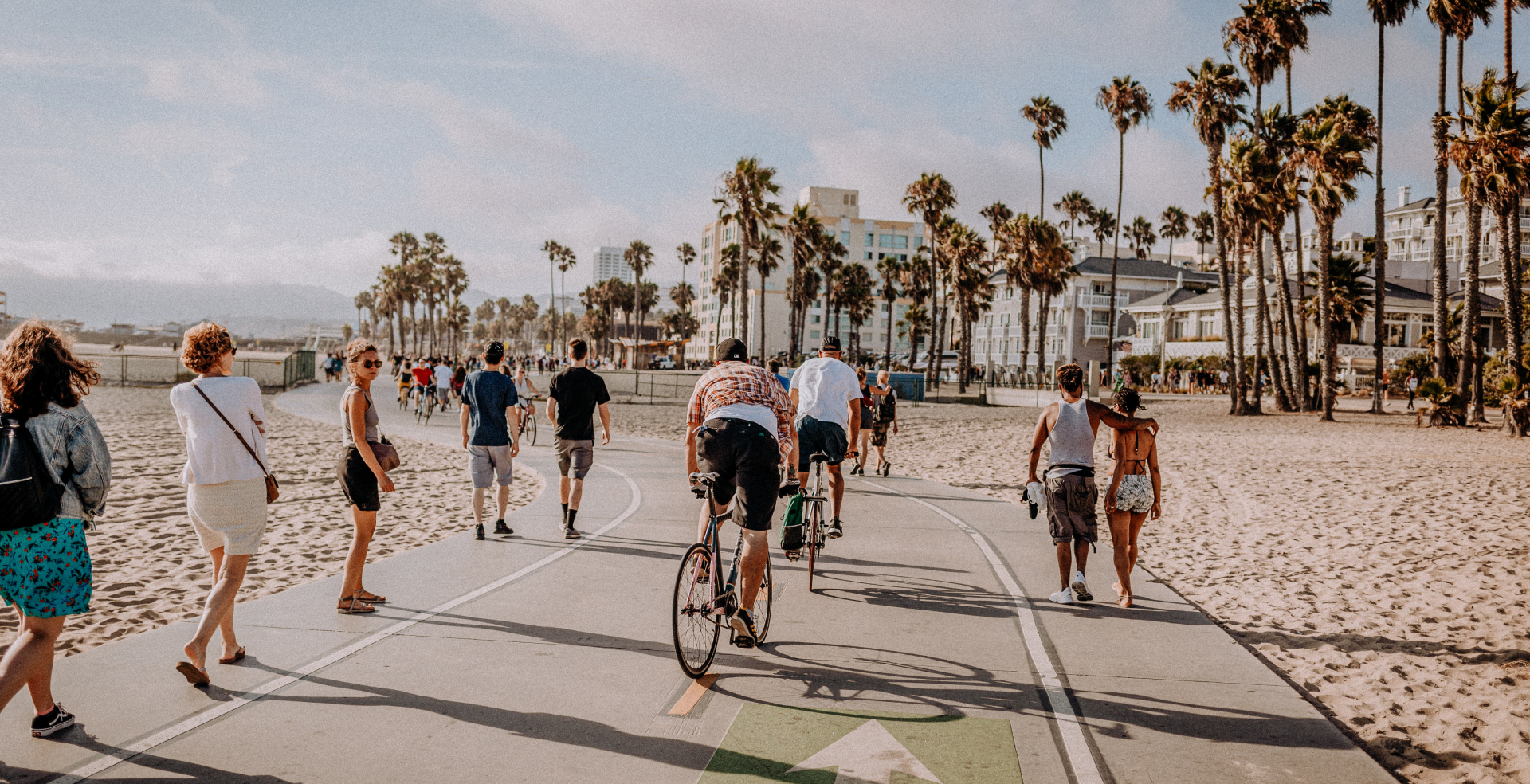 A busy walking and biking path on a beach in California.