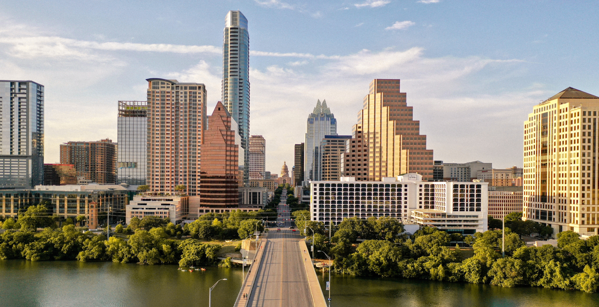 The Houston, Texas skyline with a highway overpass and a river in the foreground.