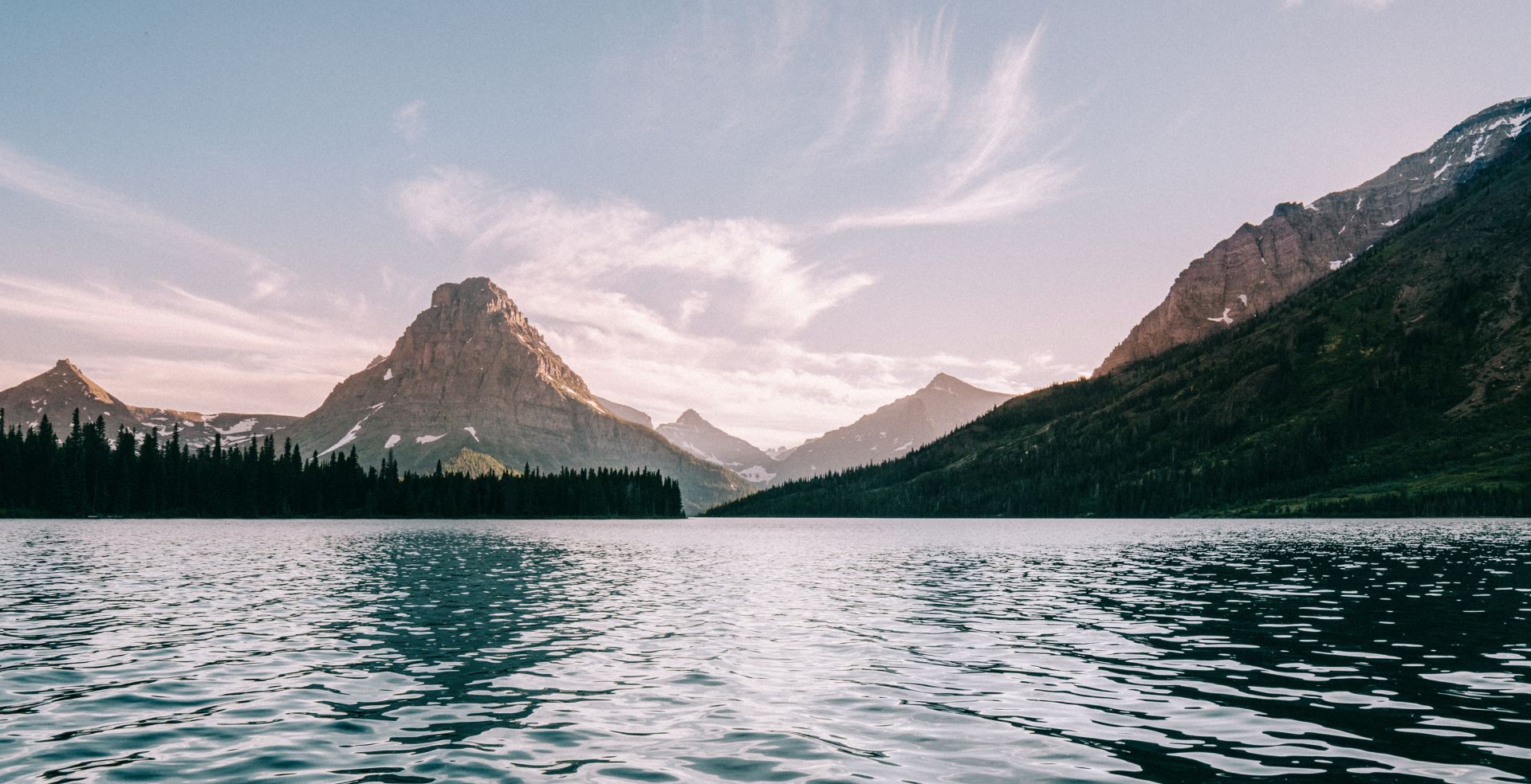 A serene lake with tall, rocky mountains in the background.