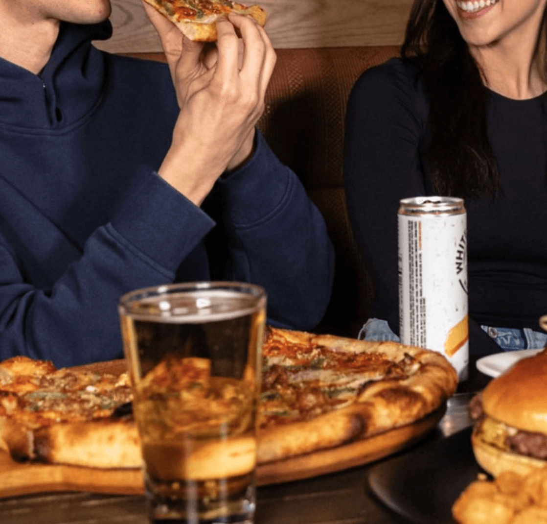 A man eating a slice of Pizza at Benmark