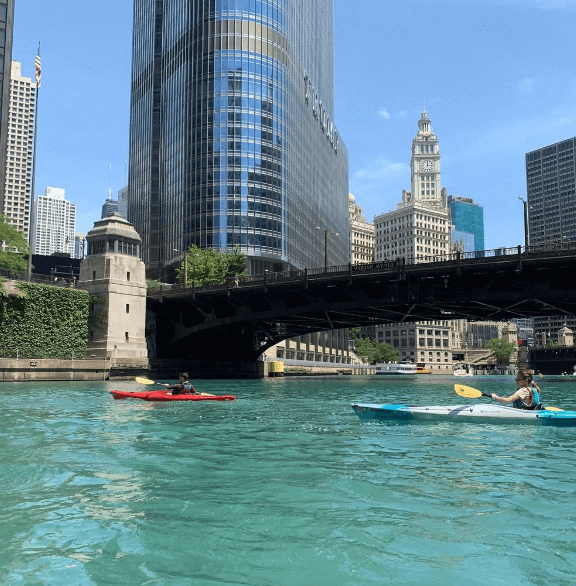 Two people kayaking under a bridge in downtown Chicago.